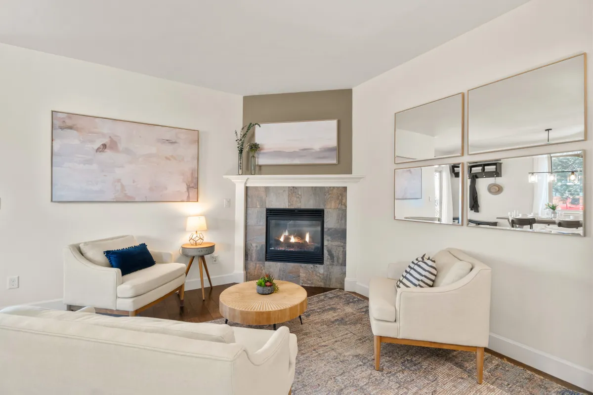 A warm and inviting living area centered around a cozy fireplace, with comfortable seating, a coffee table, and thoughtfully chosen artwork. The layout encourages both intimate gatherings and peaceful solitude.